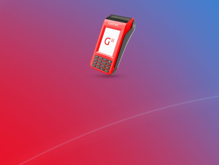 Mão da atendente segurando a POS 3G + WIFI para a cliente digitar a senha do cartão