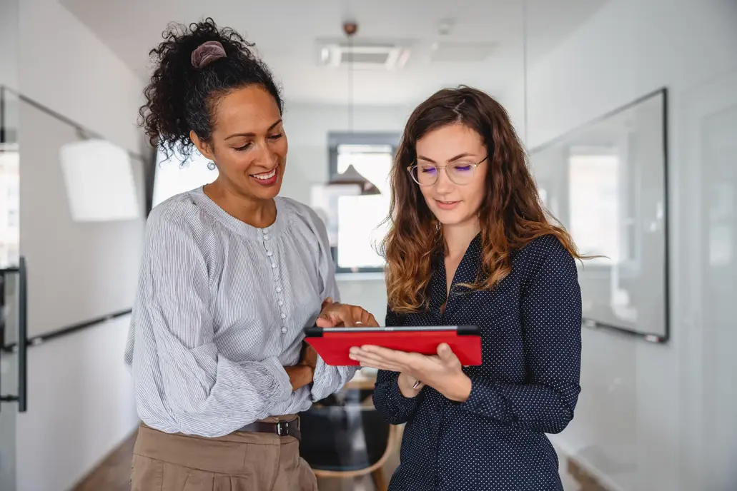 Precificao Duas mulheres mexendo em um tablet